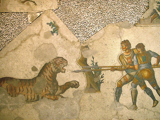 Art showing two men with spears facing a tiger